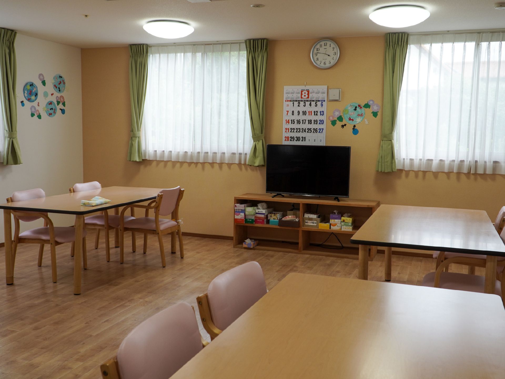 木製の机が並んだ窓のある広間