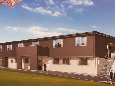 2階建ての建物の側面には屋外階段があり、1階部分が白、2階部分がダークブラウン。