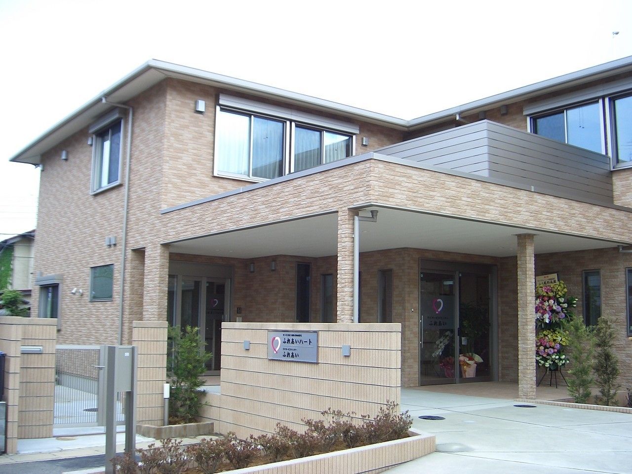 立派な門が付いた大きな一軒家といった雰囲気のホーム。2階建てでレンガ調の外壁が温かい雰囲気。