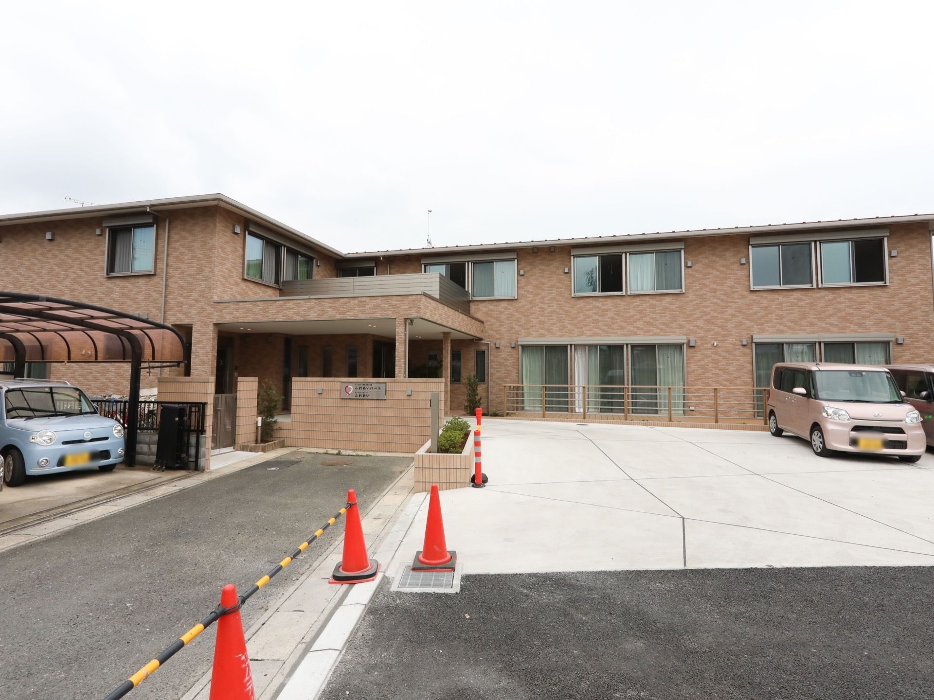 施設の外壁はブラウン色が基調になっており、２階建てである。建物の前には大きな駐車場が設置されている。