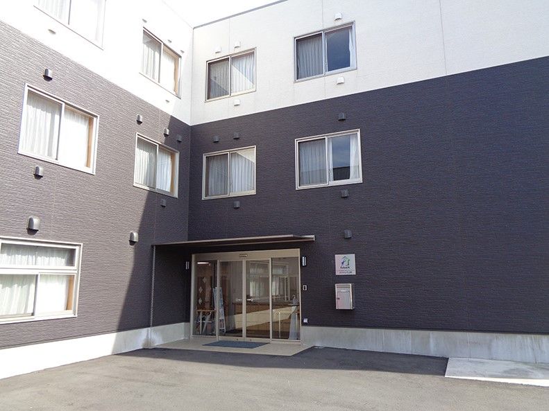 エクラシアの看板がある、ツートンカラーの外壁の3階建て建築物