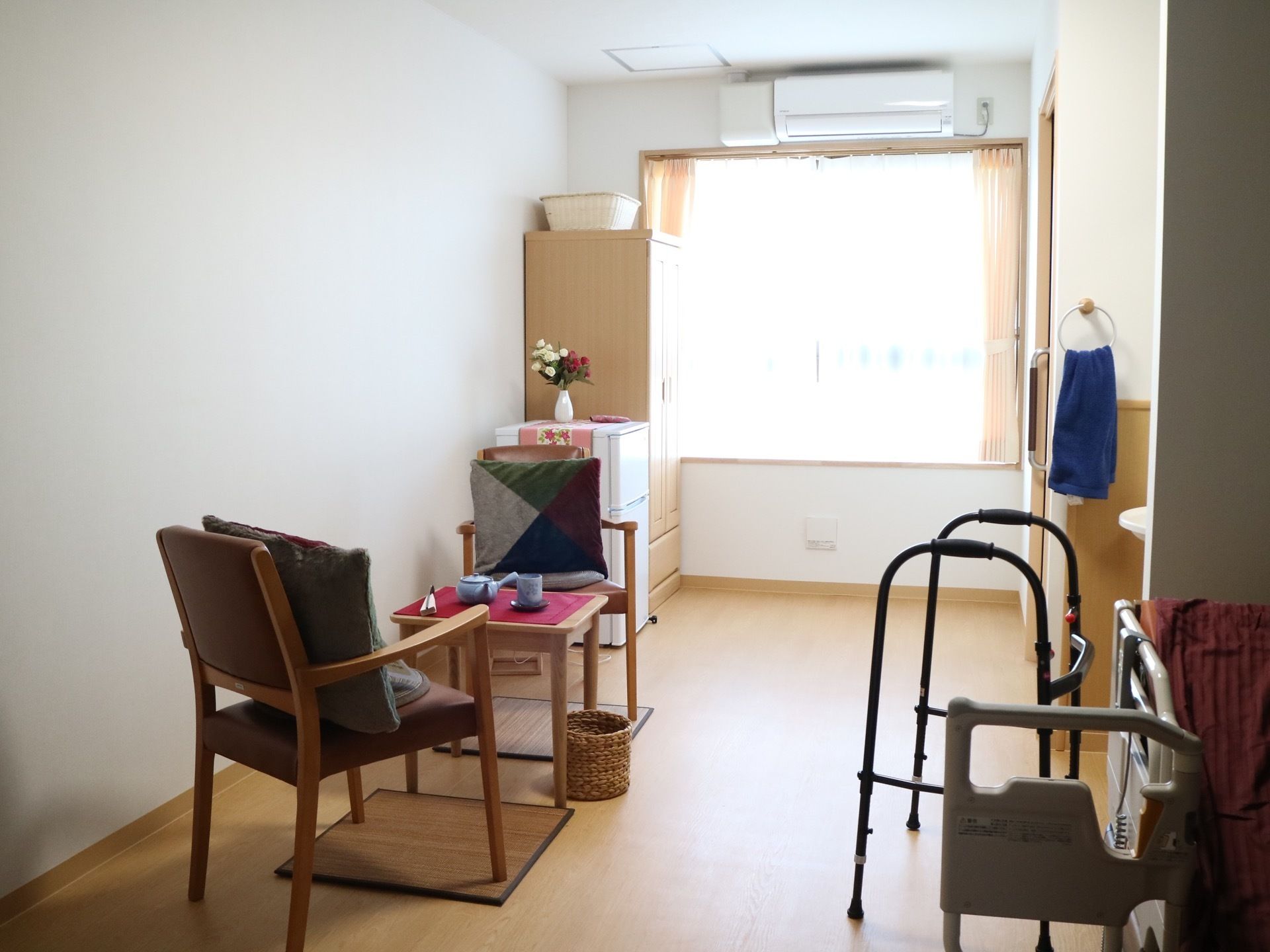 居室の奥側はリビングスペースとなっている。収納タンスや冷蔵庫を備えている。コンパクトなテーブルセットがあり、ちょっとした飲食もできる。