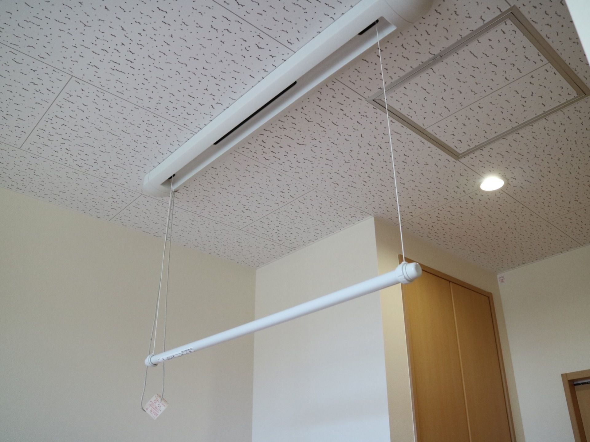 居室内に、出し入れ可能なパイプハンガーがある。使用しないときには天井に取り付けられているケースに収納するようになっている。