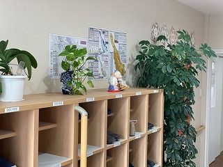オープンタイプの靴箱が置かれた玄関。靴箱には複数の靴場置かれ、館内の壁や靴箱には手すりが付いている。
