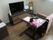 テレビや一人用のいす、テーブルなどが置かれているフローリングの部屋にはカレンダーが飾られている。
