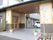 車寄せもできる広いピロティがある。無垢材や瓦屋根で日本家屋風に造られており、奥は駐車スペースになっている。