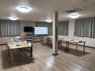 大きなテレビやホワイトボードがある共有スペースには、ダイニングテーブルも置かれている。