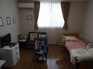 寝具付きのベッドやソファ、エアコンが付いたフローリングの部屋にはカーテンが付いた大きな窓もある。