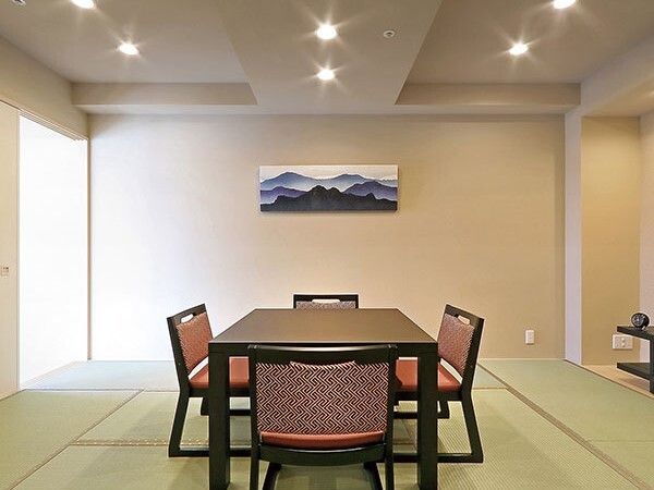 畳敷きの部屋には、和風のテーブルセットが置かれ、壁には白と青で描かれた山の絵が飾られている。