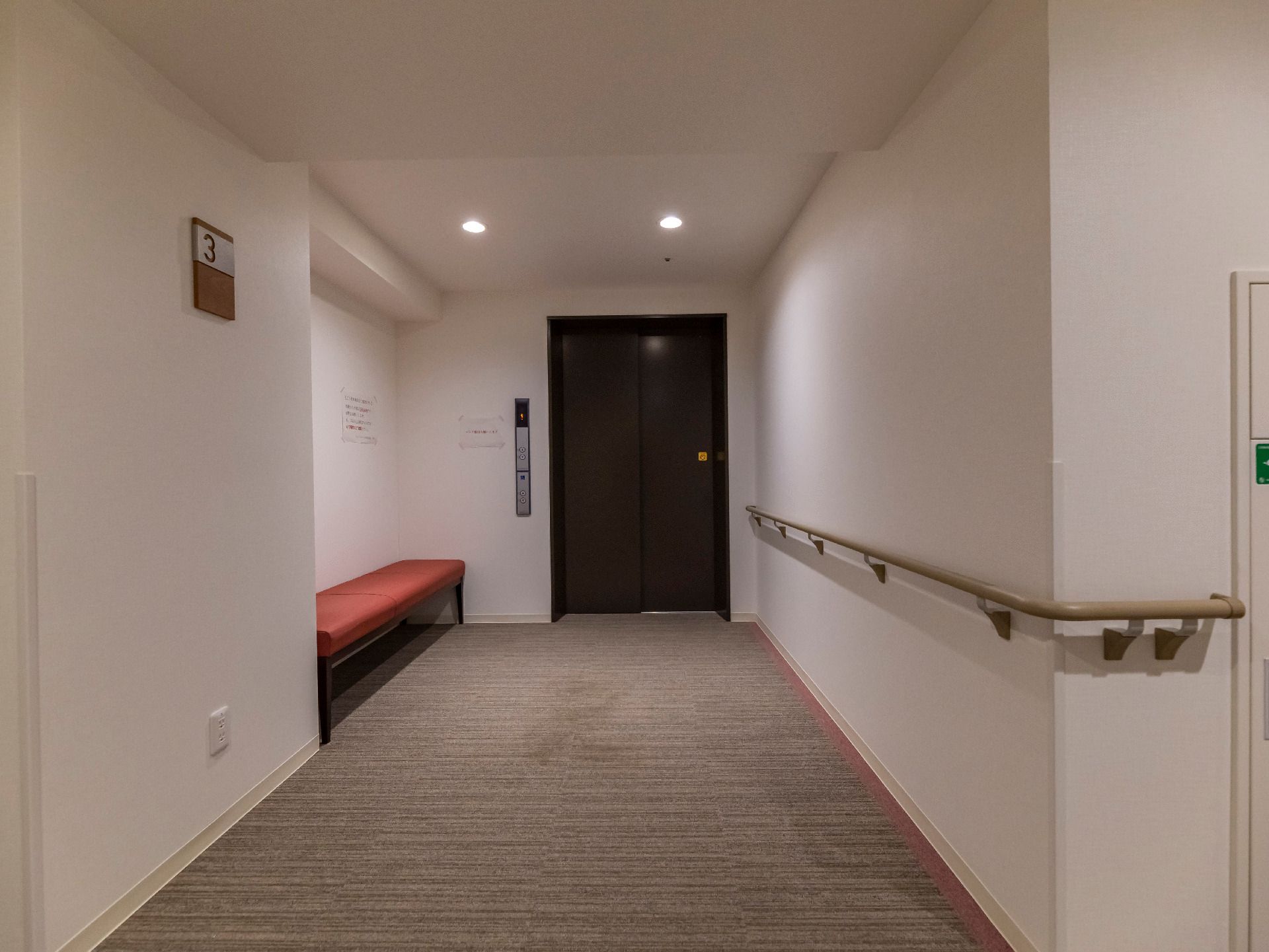 扉前に休憩用の椅子が置かれているエレベーター