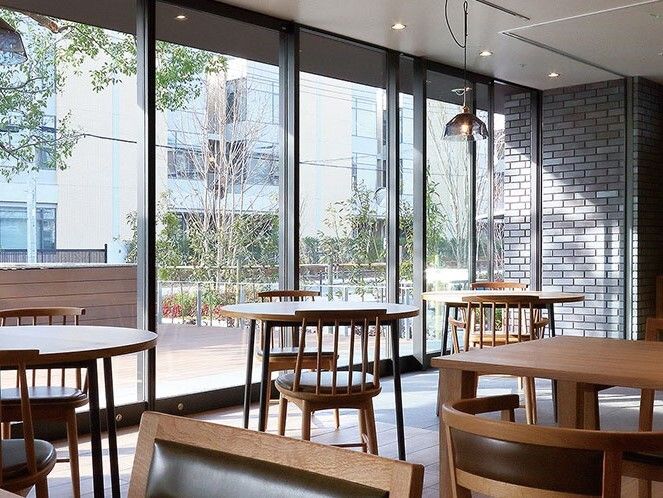 二人用のテーブルが複数置かれたカフェ風の食堂。壁一面が窓となっていて、外の景色を眺めることができる。