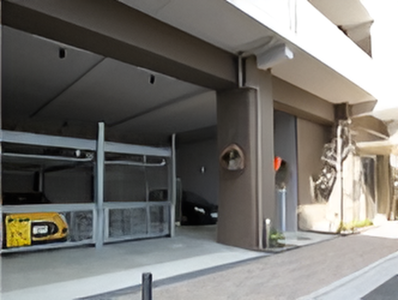 1階部分が駐車場となっていて、複数台の車が止まっている。その前にはレンガが敷かれたアプローチもある。
