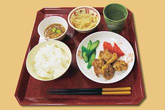 煮物やトマトやスライスしたきゅうりに、小鉢が2品付いたメニュー