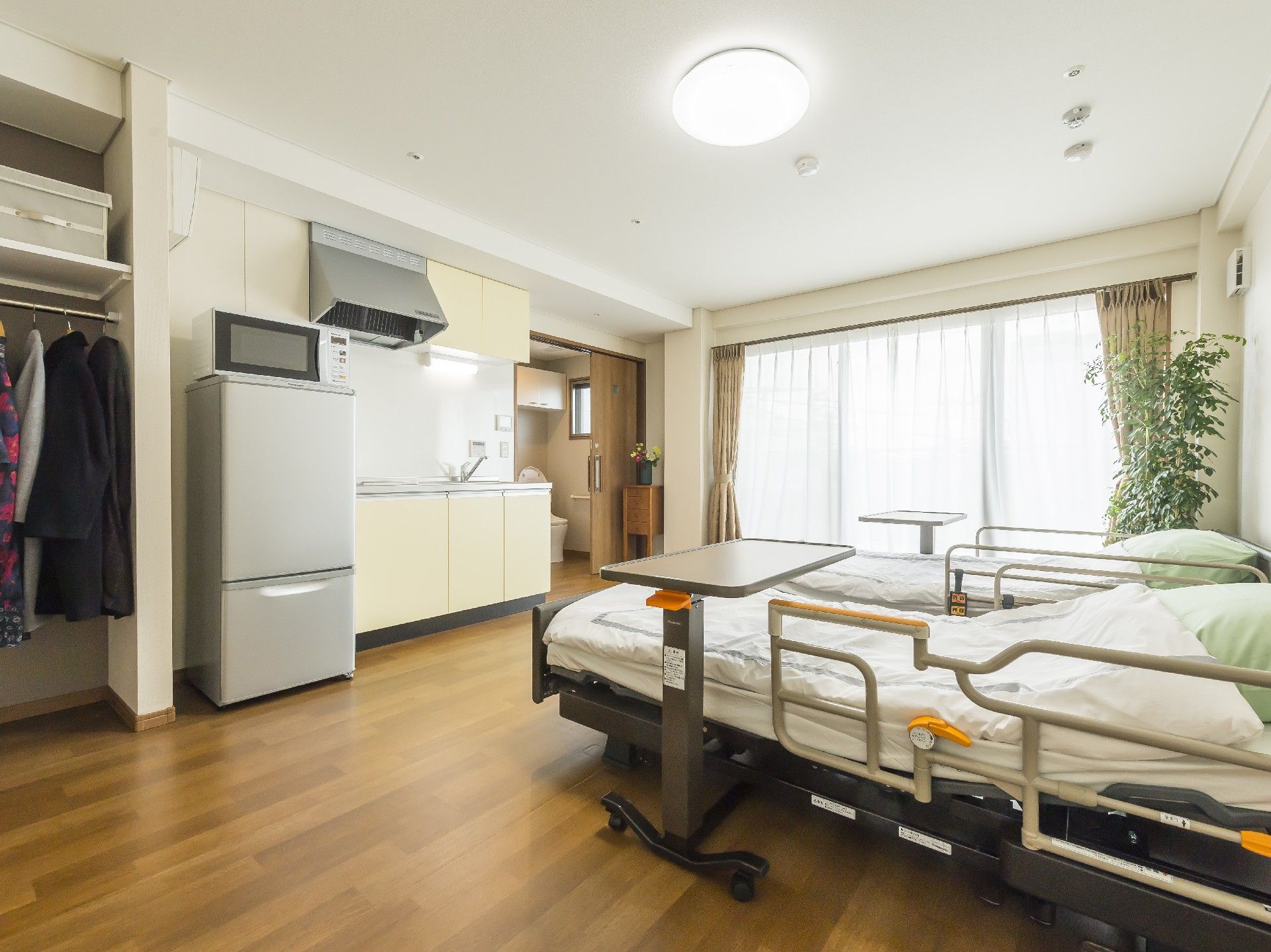 冷蔵庫や電子レンジ、キッチンが付いた広い居室には介護用ベッドやトイレもある。