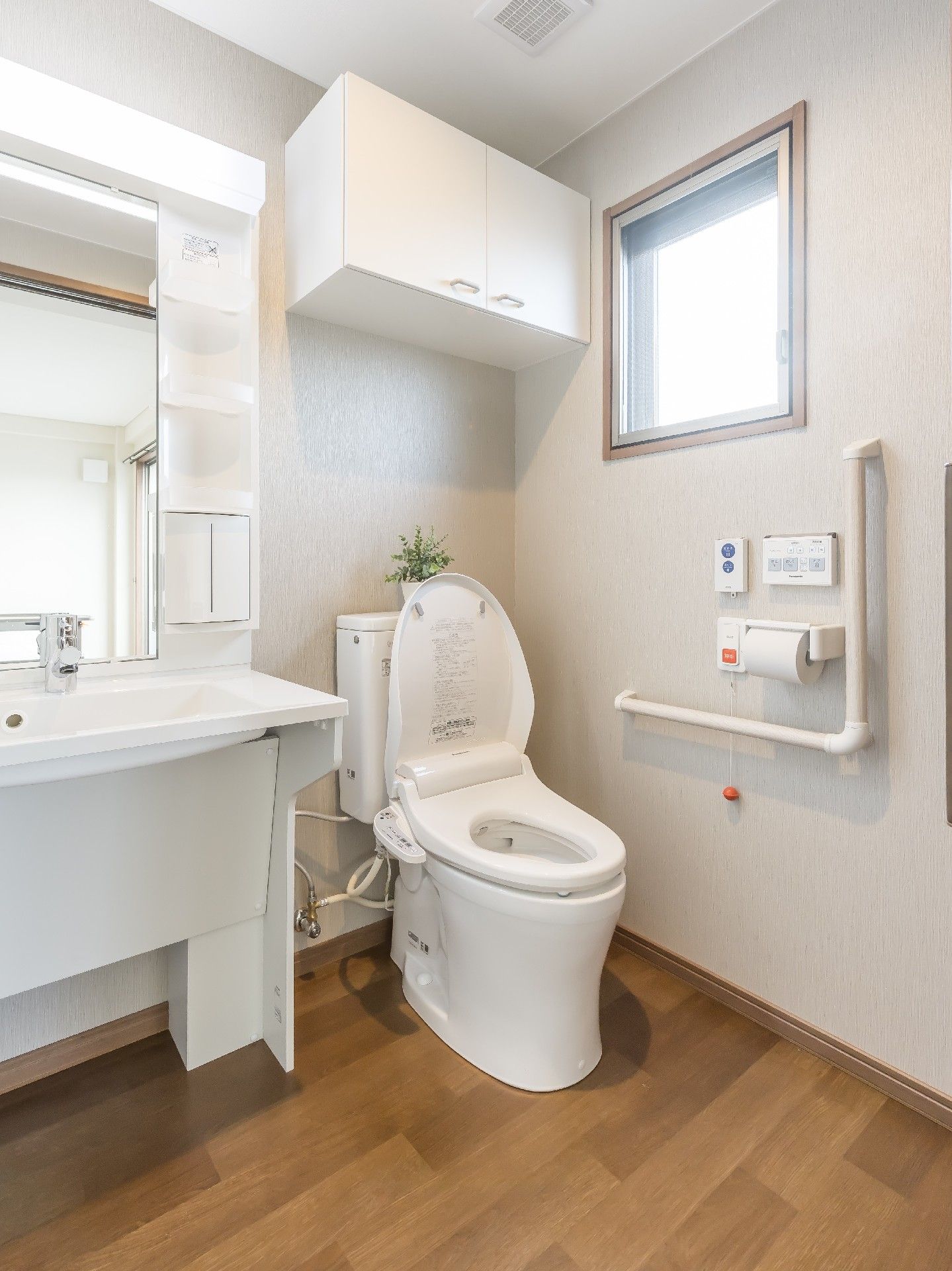白を基調としたトイレには手すりや呼び出しボタンも付き、洗面所もある。