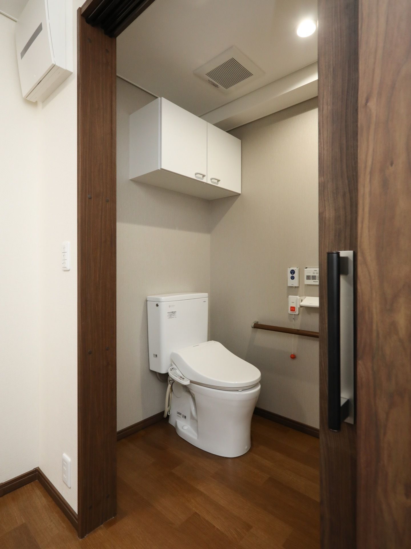 トイレの中は天井が固く、広々として清潔感がある。壁には作り付けの棚があり、備品をまとめて収納できる。