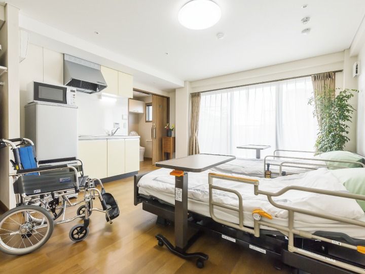 キッチンや冷蔵庫、電子レンジなどがそろったお部屋には車いすやベッドもある。