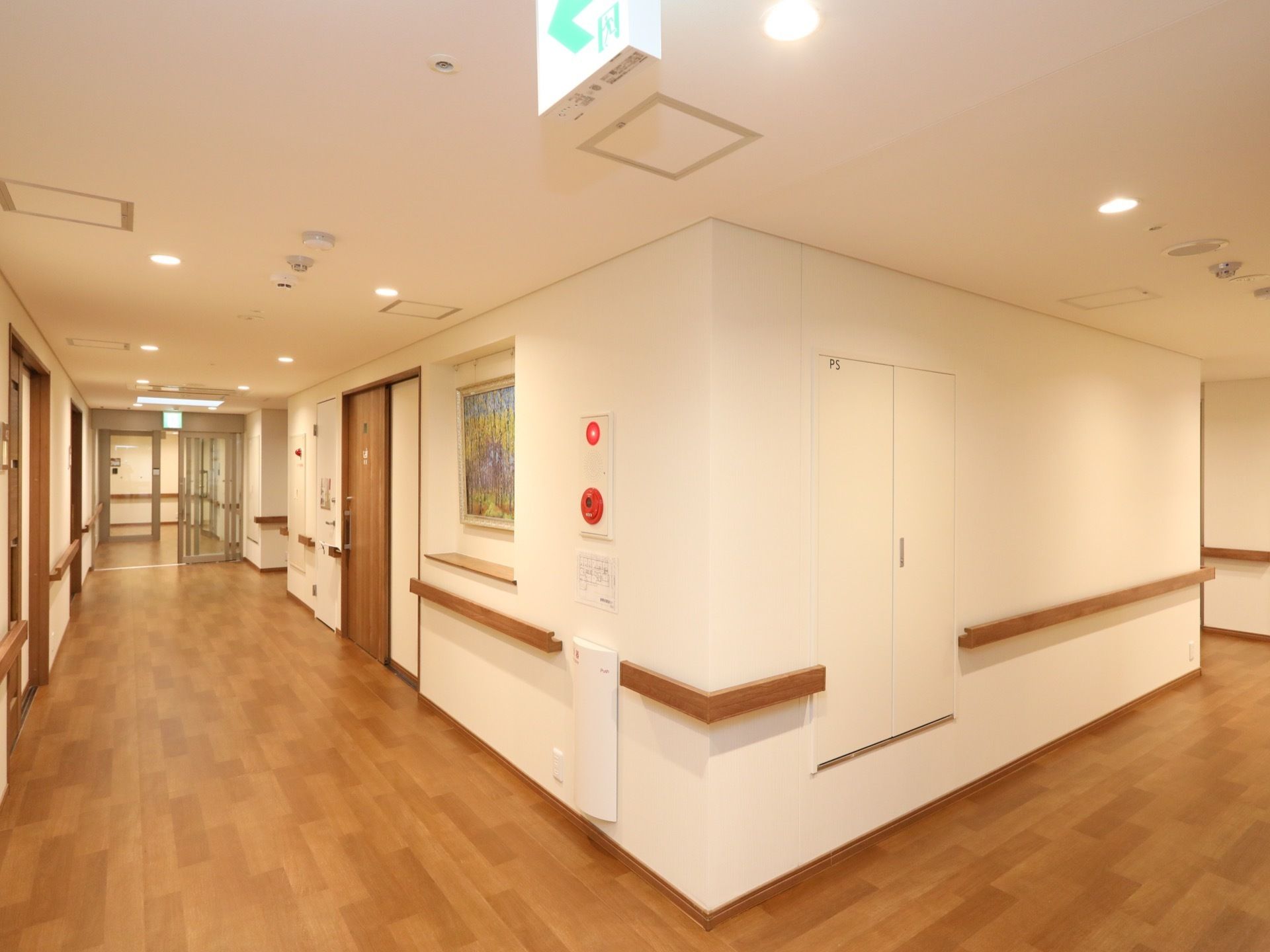 壁の一部には展示スペースがあり、カラフルな絵画が飾ってある。通路は安全のため、物を置かず広く場所が空けられている。
