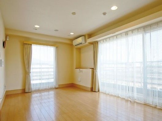エアコンが設置されたフローリングの居室には窓が付き、カーテンも付いている。
