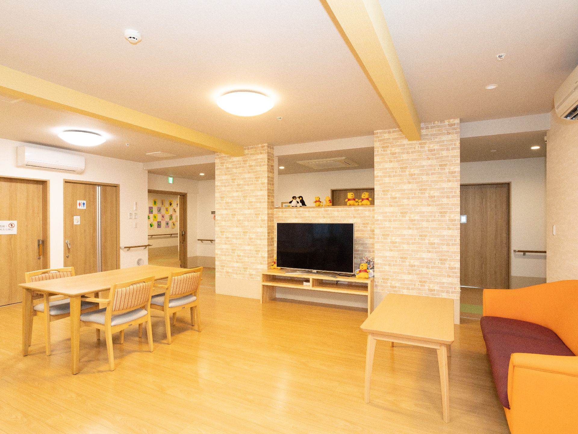 介護車両の前にいる車椅子に座っている高齢の男女と介助をするヘルパー