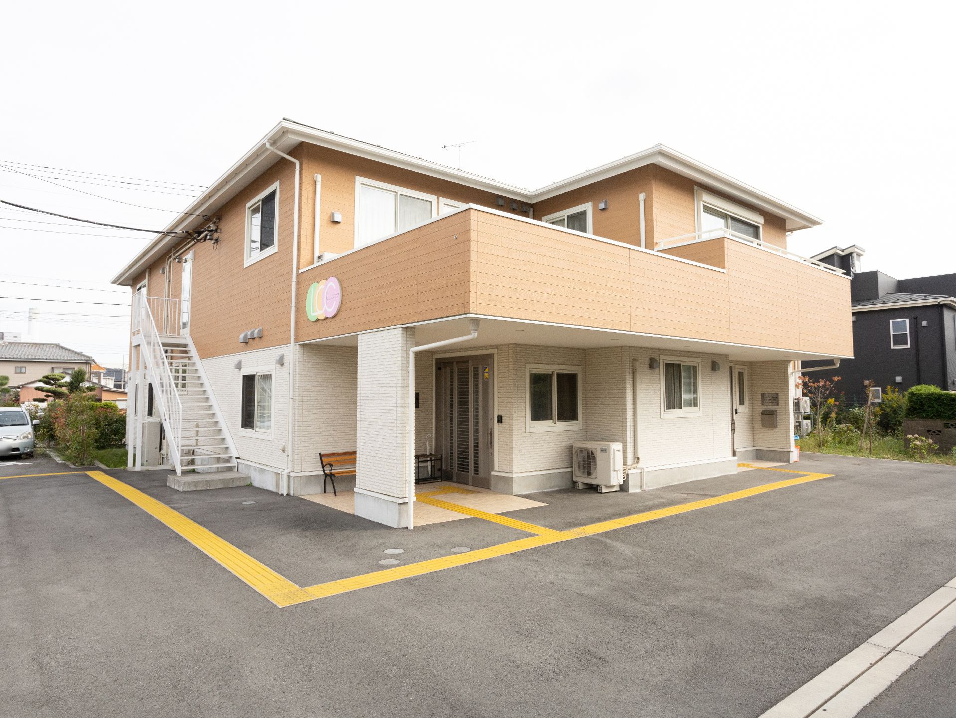 駐車場から撮影した２階建ての介護施設の外観