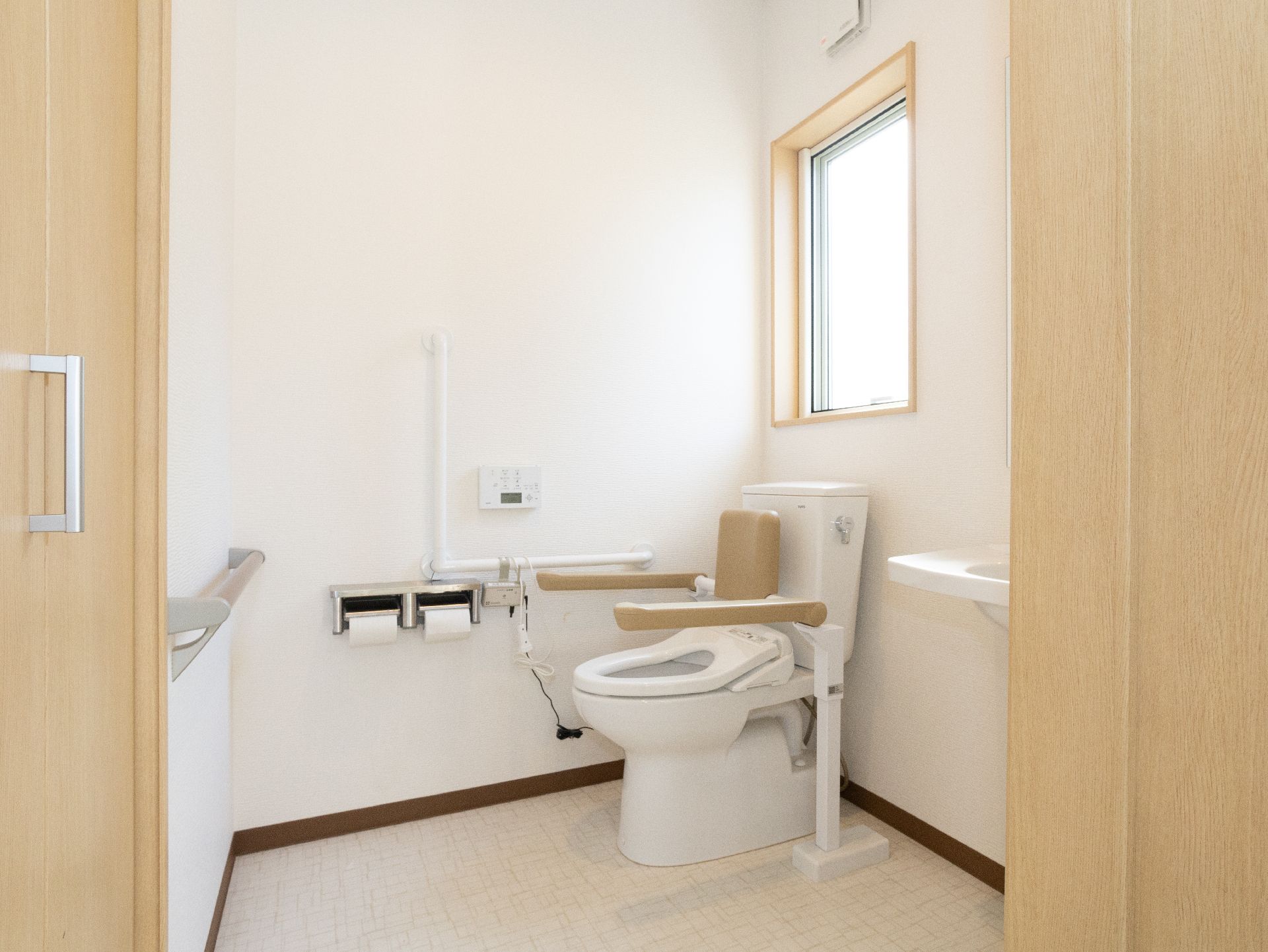 手すりが付いたバリアフリー完備の入居者向けの洋式トイレ