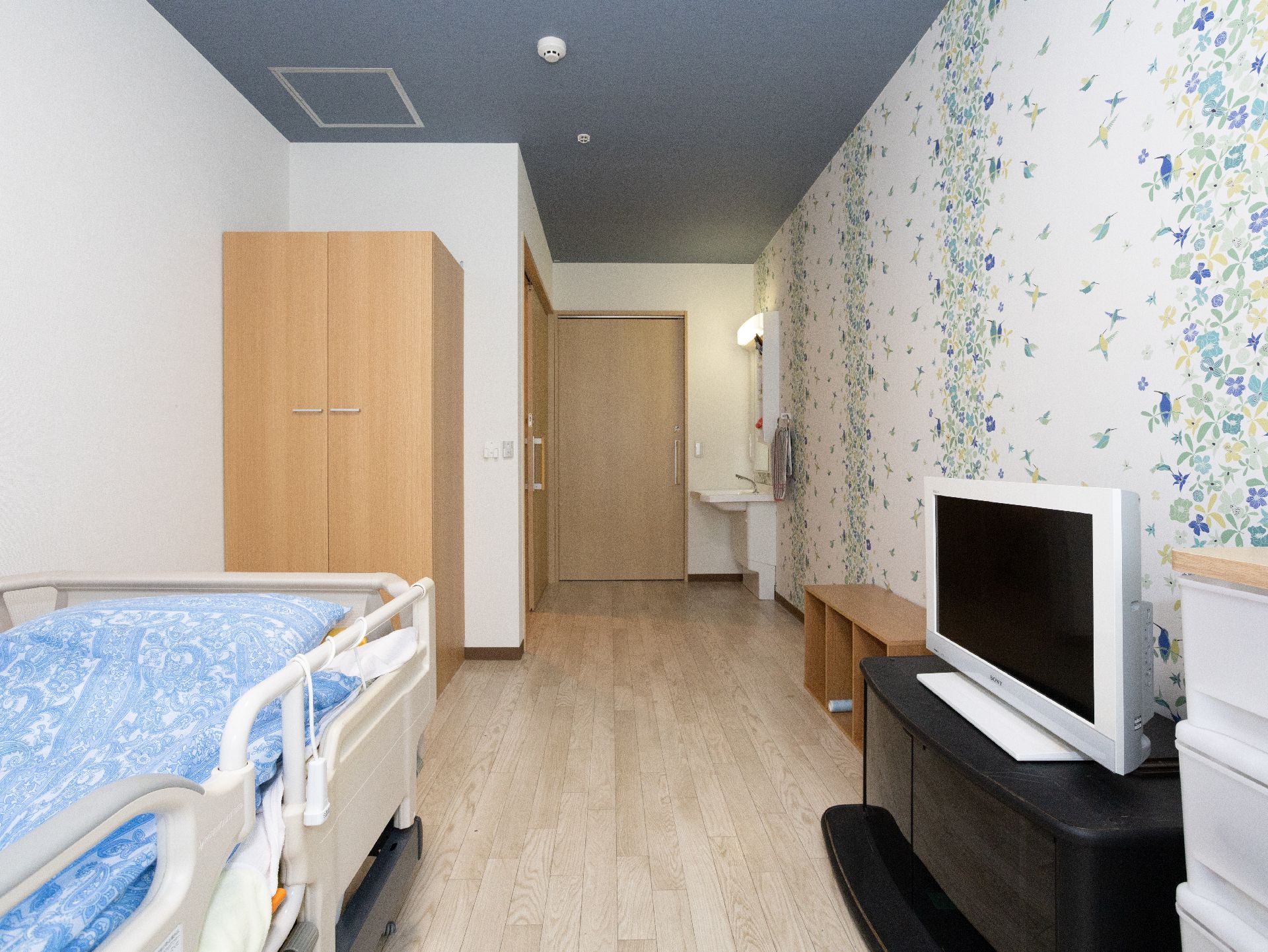 車椅子に座っている高齢女性と寄り添う女性ヘルパー