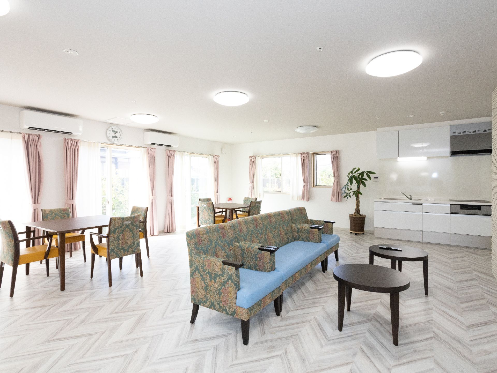 薬を飲む高齢女性に水を差し出す女性スタッフ