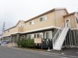 二階建てであり、クリーム色で塗られている介護施設の外観