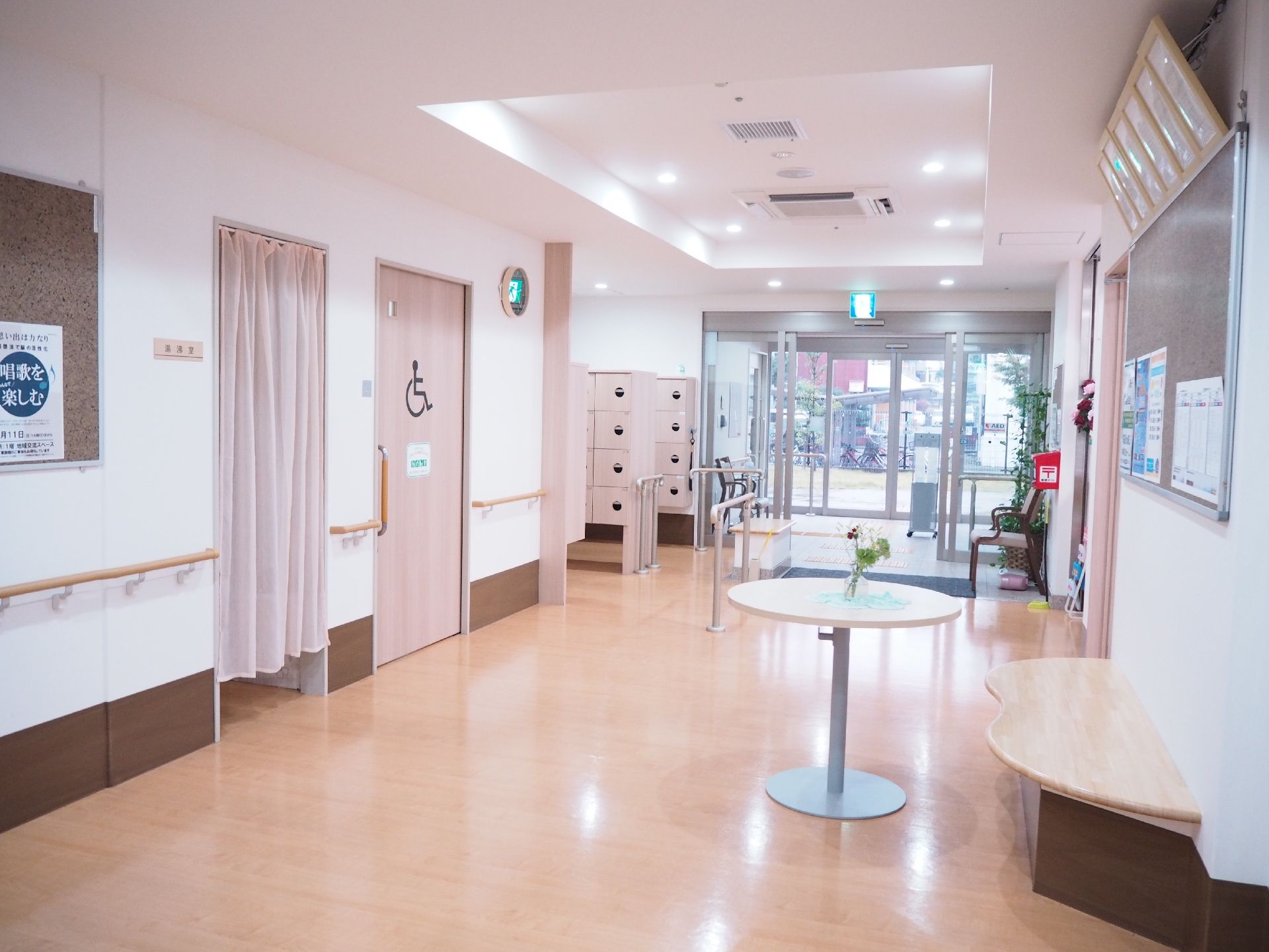 幅の広い廊下には手すりが付き、ベンチタイプの椅子やテーブルもあり、突き当りには玄関がある。