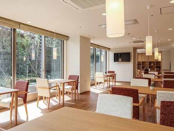 二人用のテーブルや四人用のテーブルが置かれた食堂には大きな窓があり、日当たり良好。テレビも付いている。