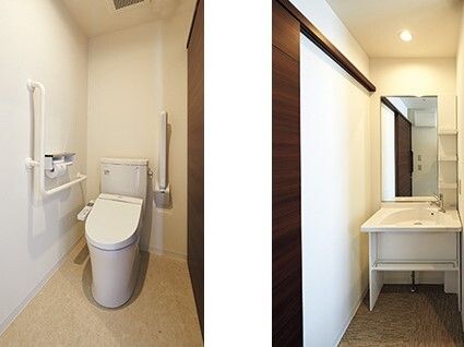 左手にはエル字型の手すりや可動式の手すりが付いたトイレがあり、右側には車いす対応の洗面所がある。