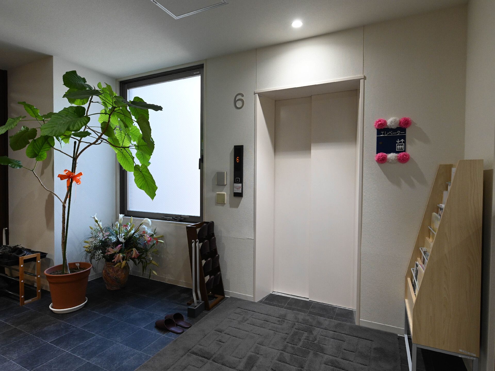 白い壁に配置された白い扉のエレベーター