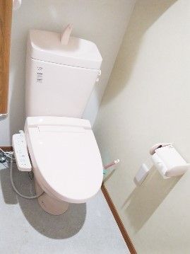 白を基調にした施設のトイレ。一般家庭によくある形の便器、壁に緊急コール