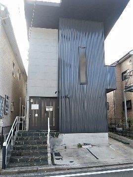 縦に長いモダンなデザインの建物の外観。ツートンカラーが印象的な建物