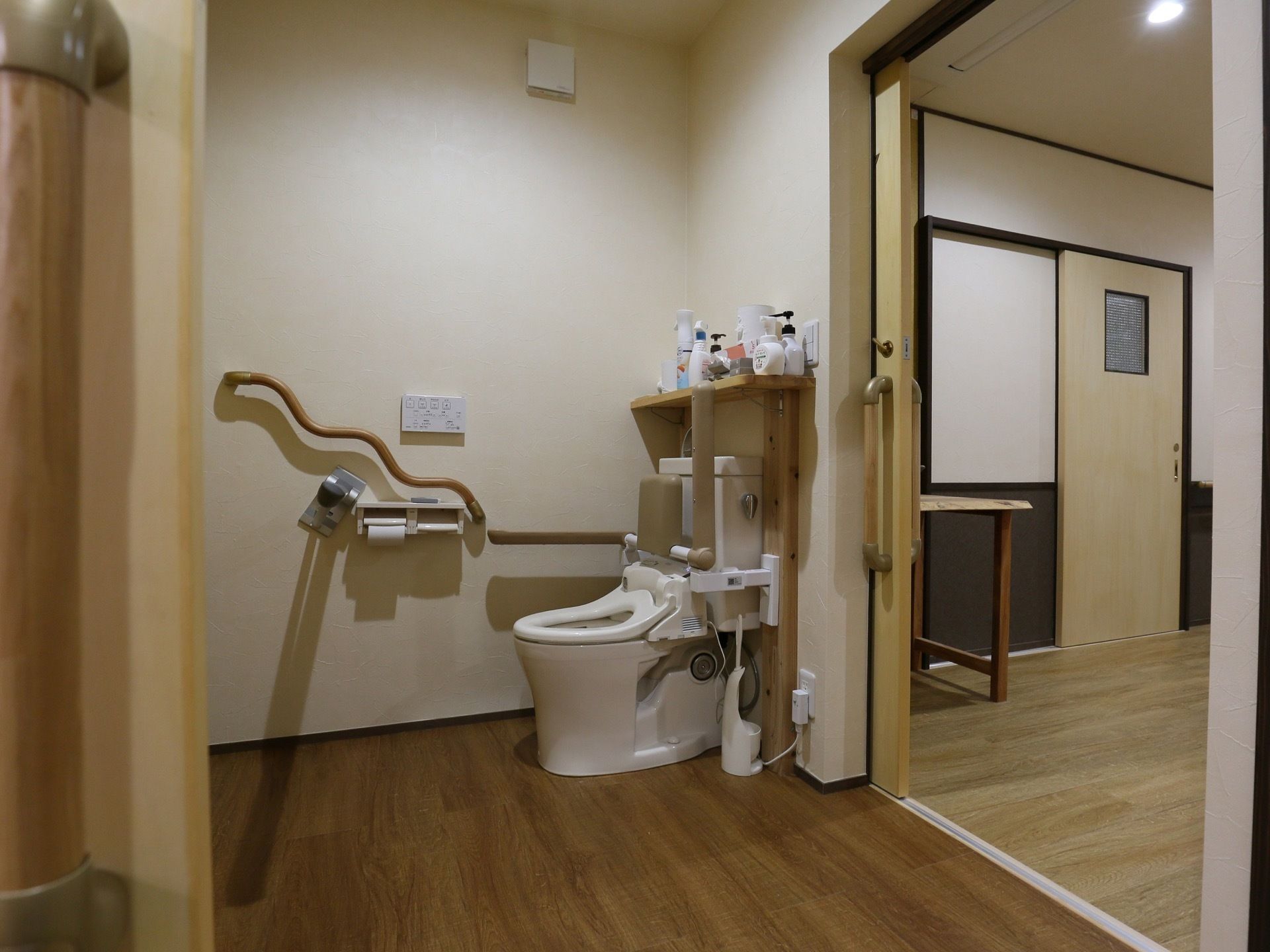 トイレの壁にはユニークな手すりを設置している。入居者様はそれを伝いながら、ゆっくりと安全に腰を掛けることが可能である。