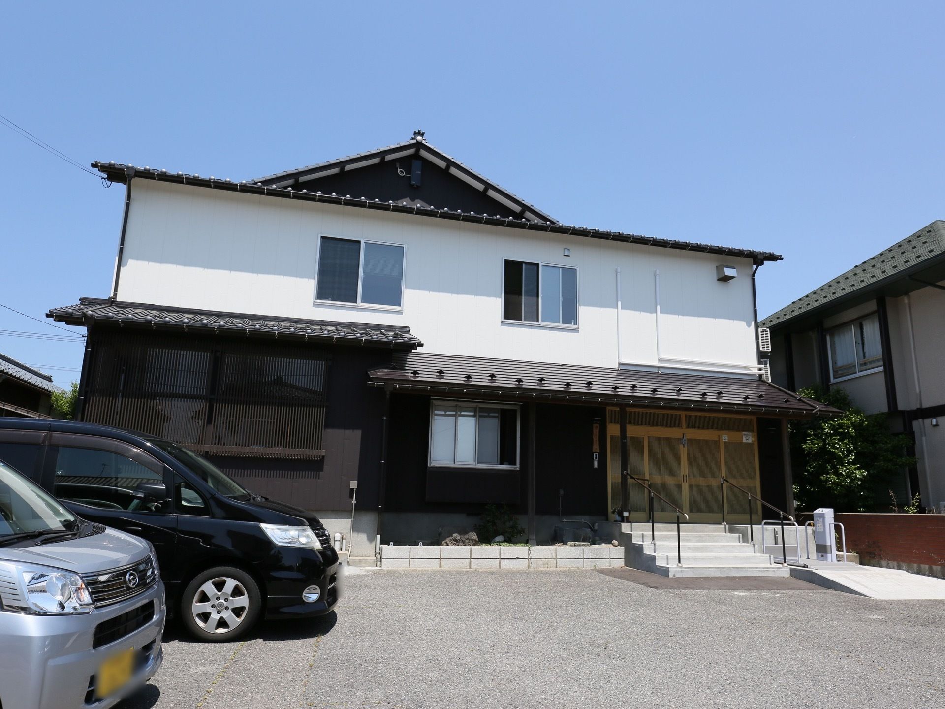 出入口には手すり付きの階段と昇降機を設置している。入居者様の身体の状況によりどちらかを選択することができる。