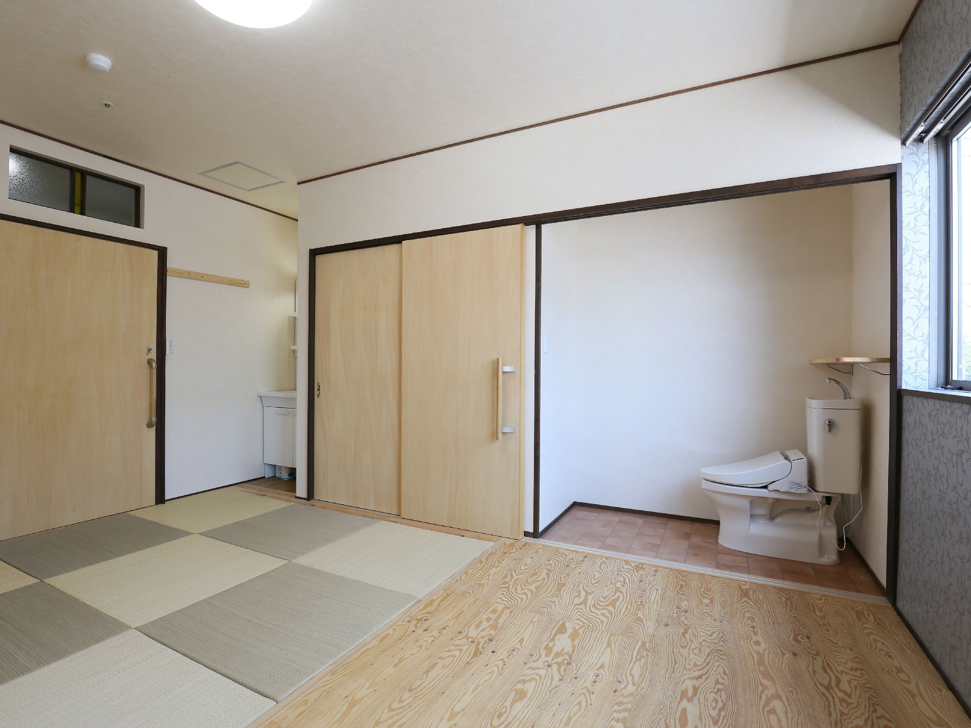 洋式便器や洗面台が備え付けられ、置き畳が施された部屋