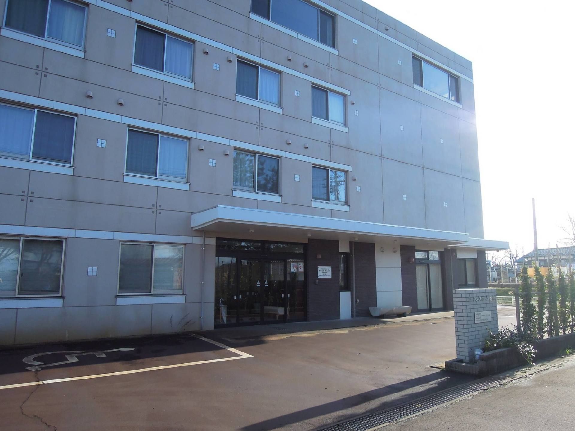 建物の入り口付近には花壇があり、木などが植えられている。玄関の前は段差がなく、入口は広い自動ドアになっている。