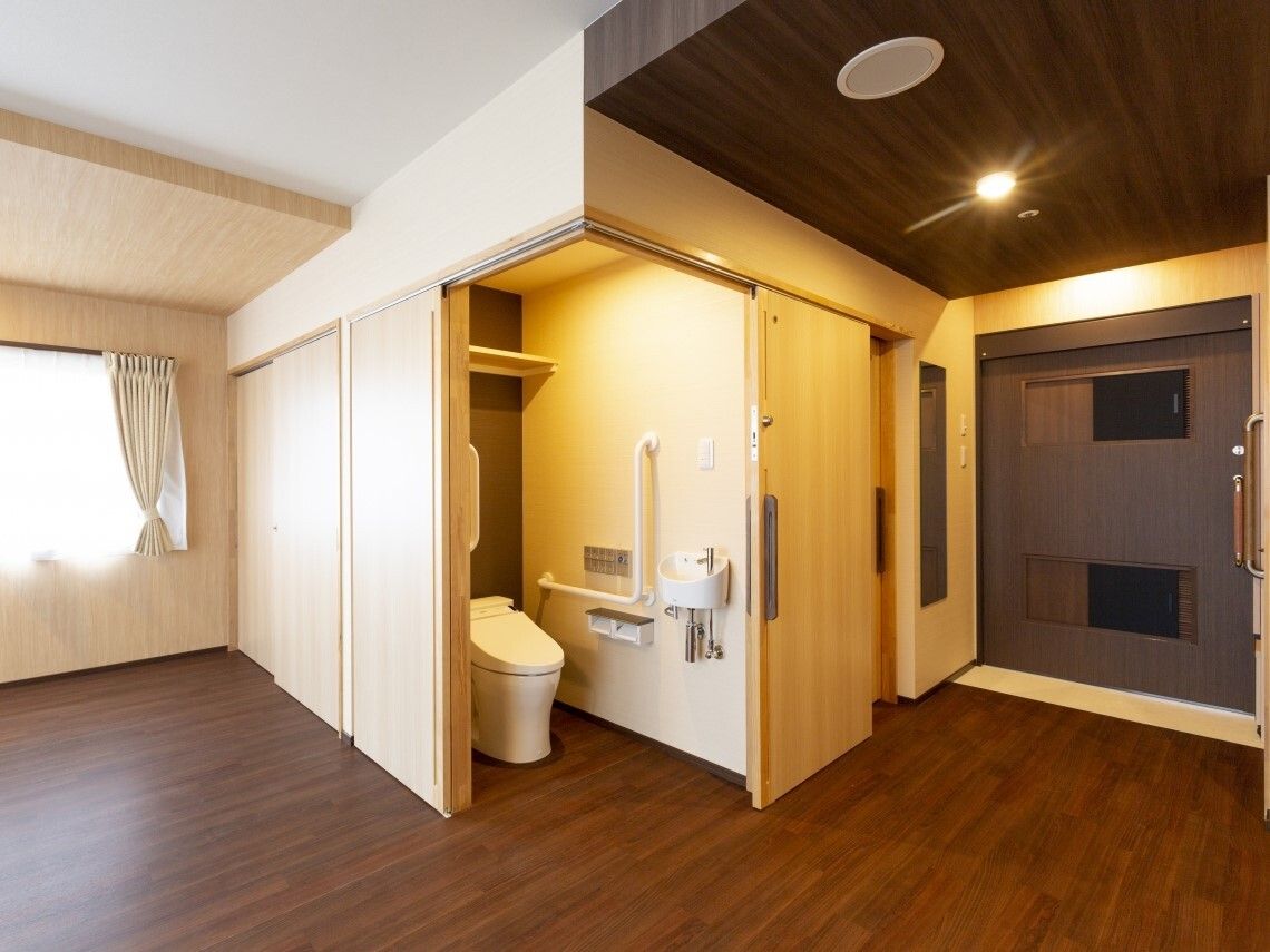 L字状に出入り口が開くトイレスペースが設置されたフローリングの部屋