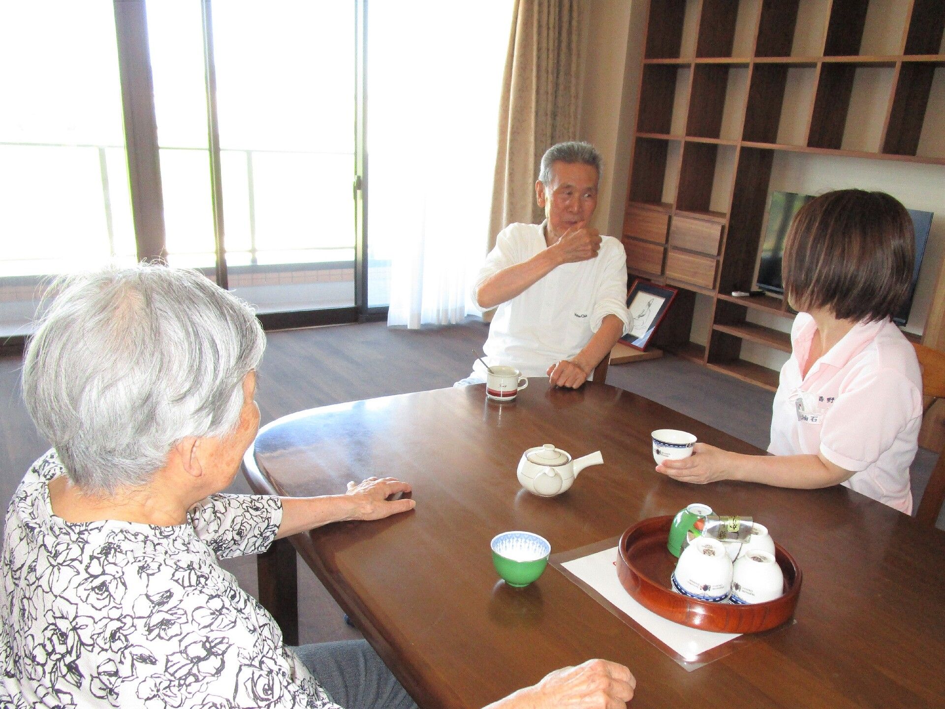 ラウンジでスタッフとご入居者がお茶をしながら会話している
