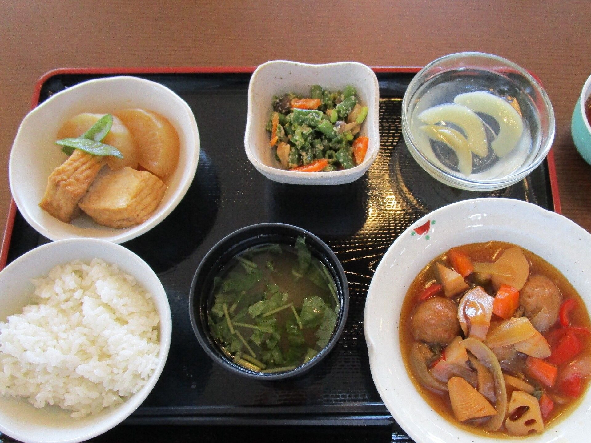 一汁三菜と果物の小鉢が並べられている黒塗りのトレイ