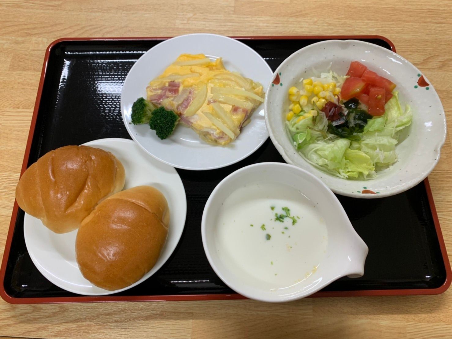 ロールパンとポタージュスープ、サラダとおかずからなる洋風の食事