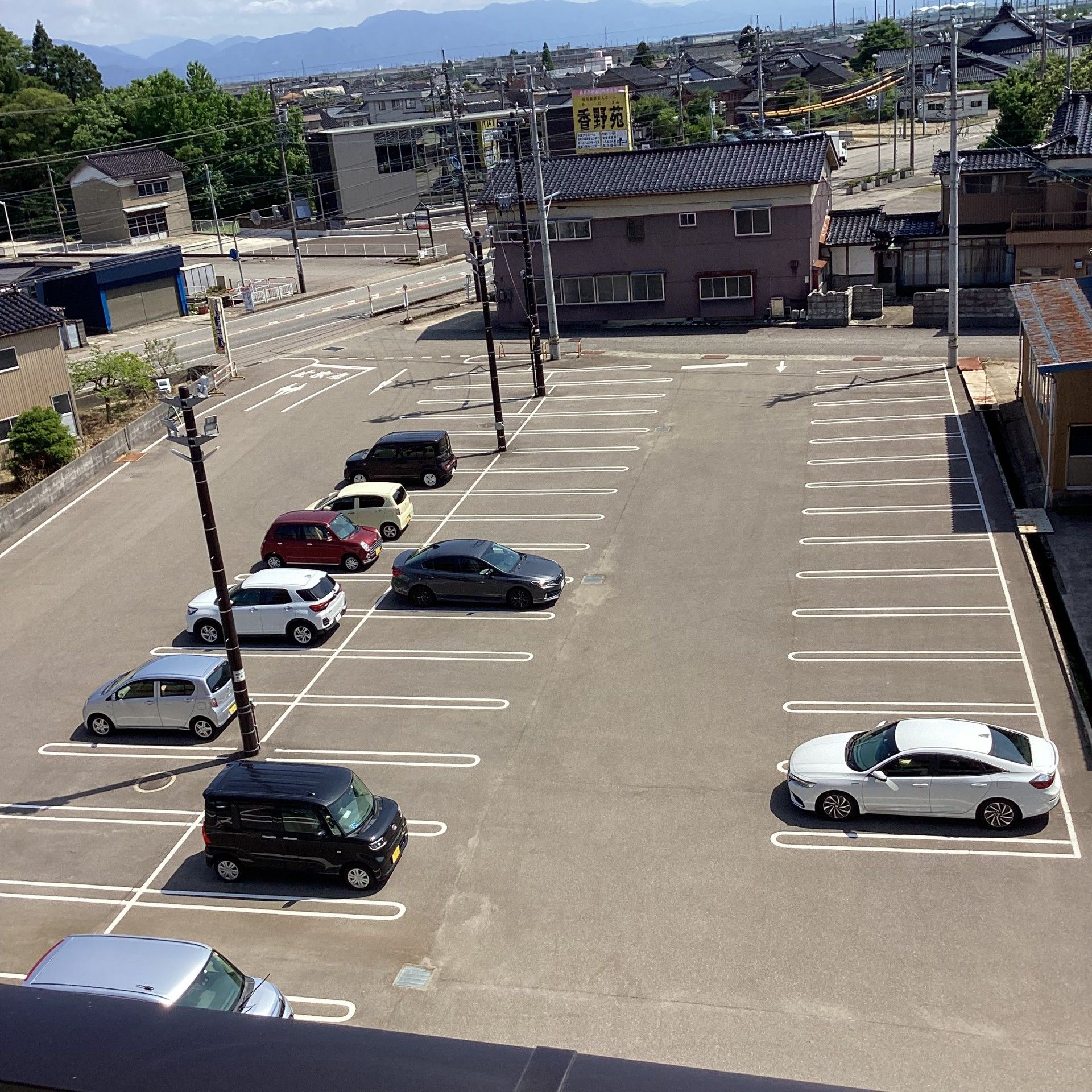 4階建ての建物はブラウン系でベランダが付き、玄関部分には住宅名が書かれている。