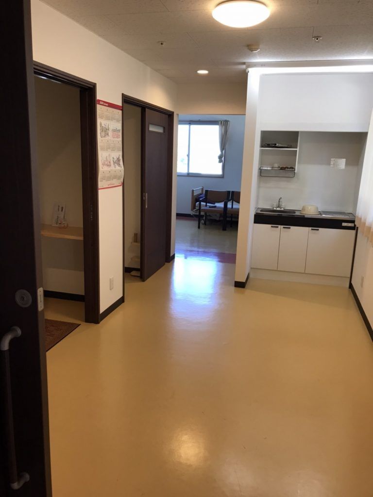 キッチン付きの部屋。左側には二つドアがあり、開いている。奥にも一つほかの部屋がある。