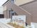 施設名が書かれた館銘板が建てられていて、その後ろにはベージュとブラウンの2階建ての建物が建っている。