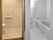 手すり付きのトイレが左側、手すり付きの浴室が右側にあり、どちらもゆったりとした広さがある。