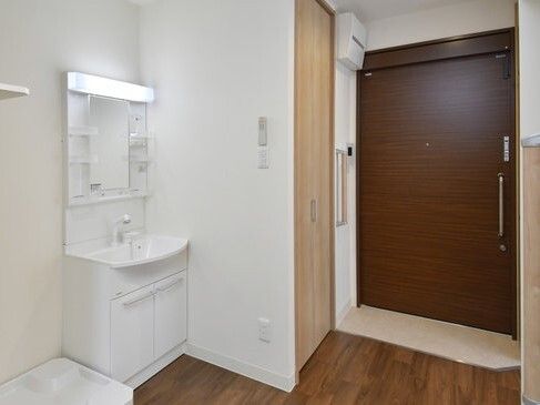 洗濯もの置き場と大きな洗面所が設置されたフローリングの居室には大きな引き戸も付いている。