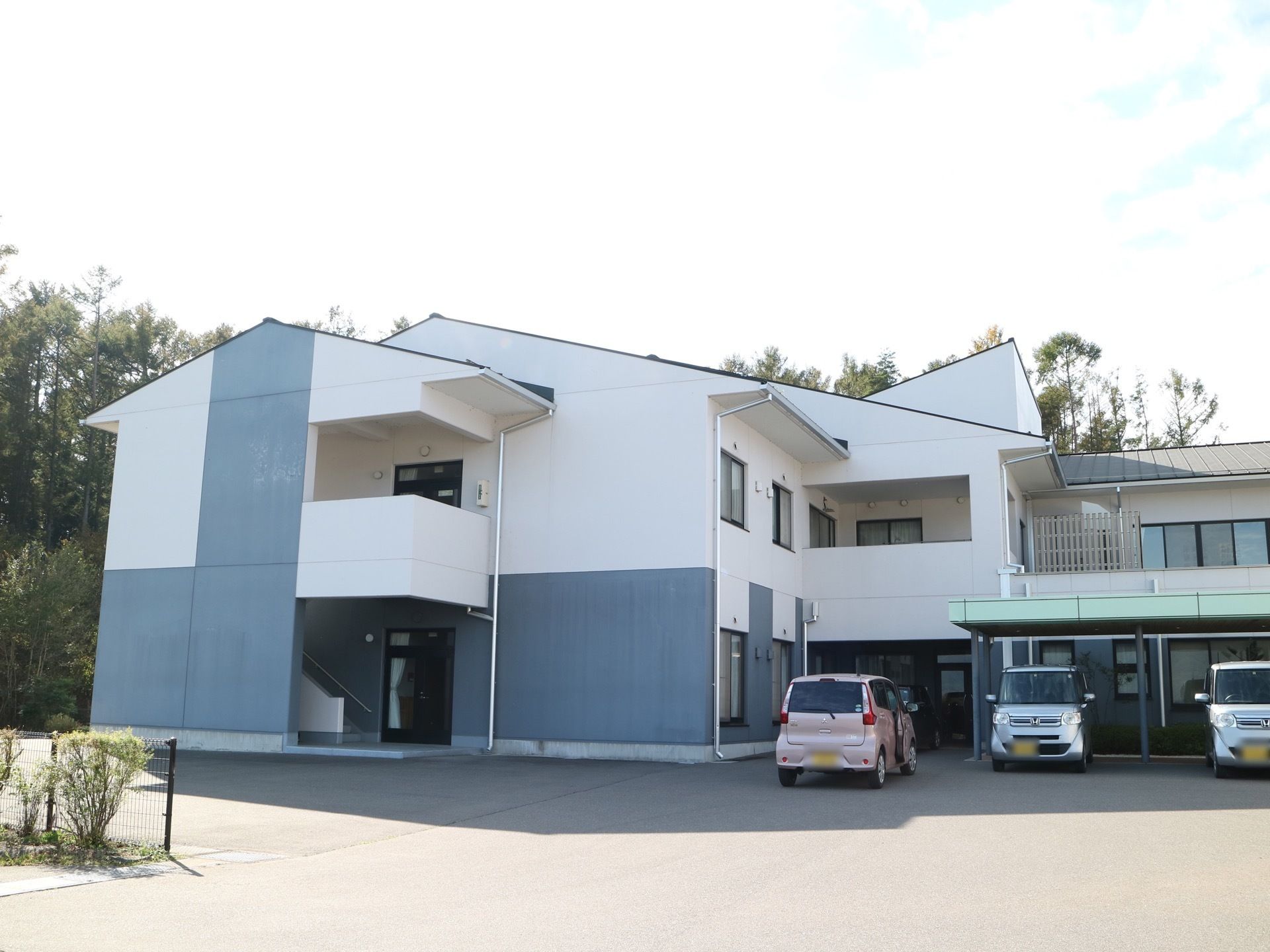 施設は２階建てになっており、１階と２階をつなぐ外階段が設けられている。建物の横にはアスファルト舗装された駐車スペースがある。