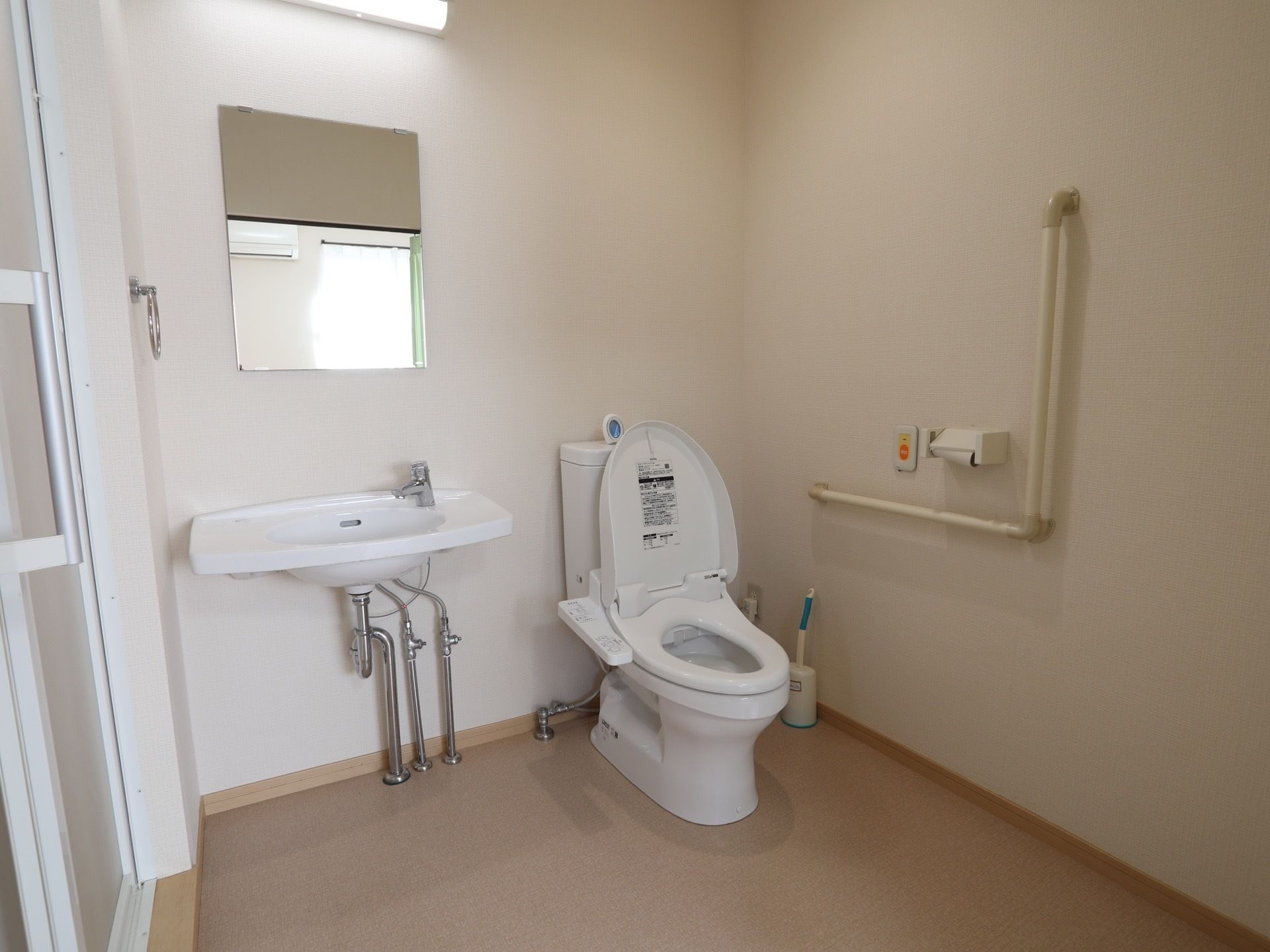 脱衣所と引き戸とトイレの機能を備えた居室のスペースである。便器の側には緊急時呼び出しボタンが備わっている。